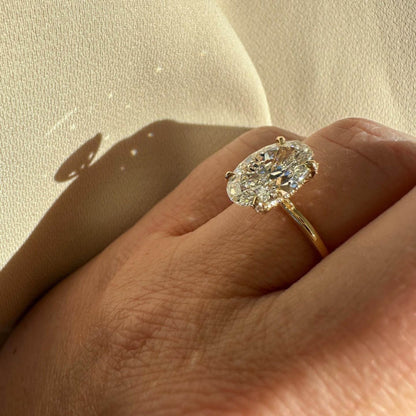 Hailey Bieber engagement ring dupe — 6 carat oval cut on gold band with halo modelled on a hand