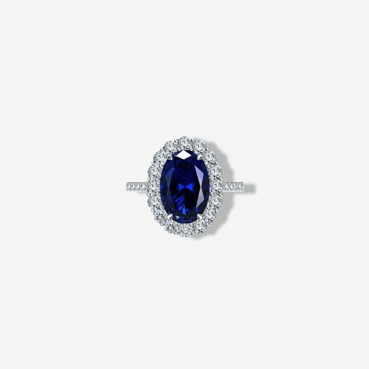 Product shot of oval Ceylon blue sapphire showing the halo setting and micro pavé silver band