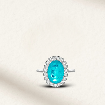 6 Carat oval cut Brazilian Paraiba tourmaline cocktail ring with trillion halo and sterling silver band