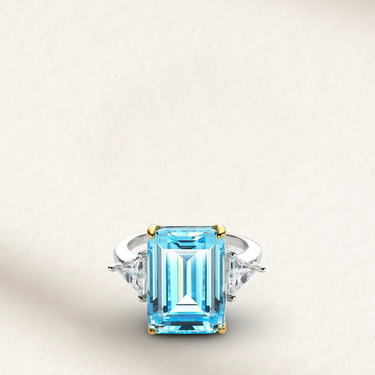 Princess Diana-inspired aquamarine ring featuring a large emerald-cut light blue gemstone set in a sleek silver band with diamond accents.