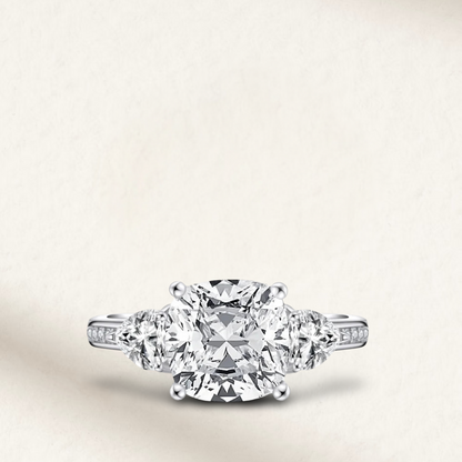 5 carat cushion cut engagement ring with white brilliant stone, three-stone demi channel setting, and 925 sterling silver band.