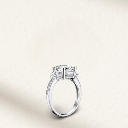 5 carat cushion cut engagement ring with white brilliant stone, three-stone demi channel setting, and 925 sterling silver band.