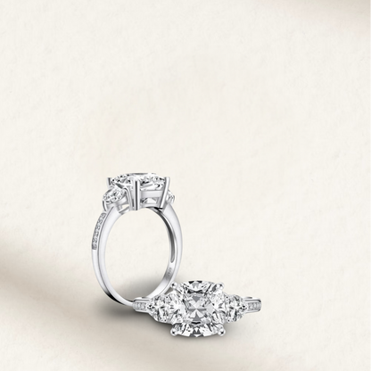 5 carat cushion cut engagement ring with white brilliant stone, three-stone demi channel setting, and 925 sterling silver band.