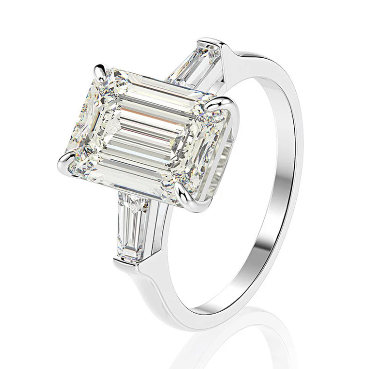 Our exceptional 5 Carat Emerald Cut Engagement Ring makes the perfect promise ring or proposal ring for her! Boxed and ready to go, our emerald cut ring will make the perfect gift for her. The centre stone is flanked by tapered baguettes in a truly timeless fashion by Margalit Rings